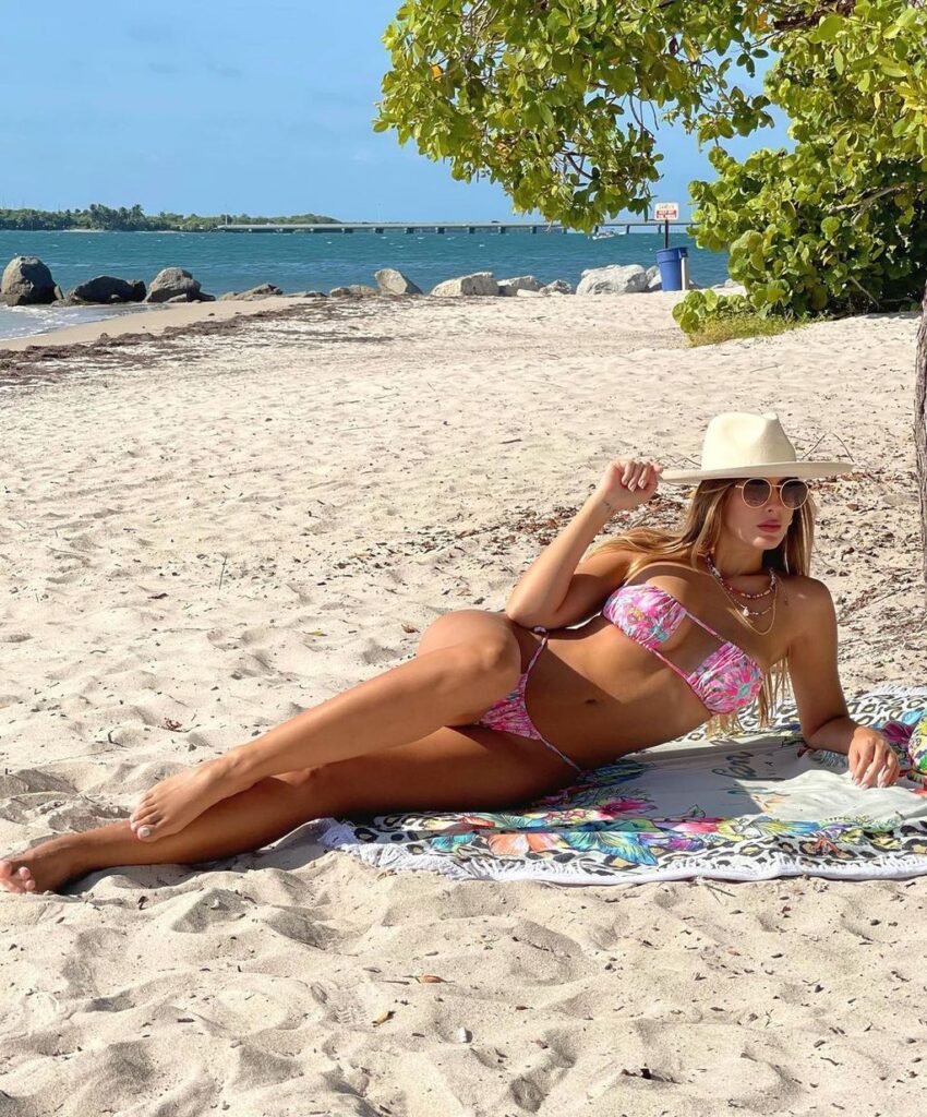 Foto de Shannon de Lima posando en una playa con un micro bikini y taparabos.