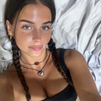 Atractiva modelo australiana con traje negro, cabello oscuro y mirada cautivadora