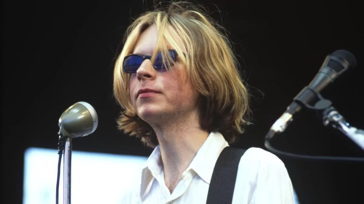 Beck tocando en el escenario con luces de fondo