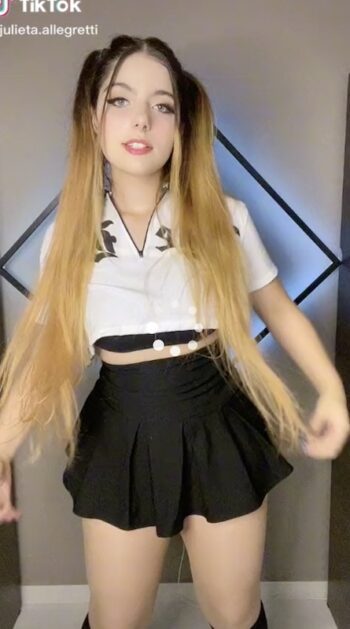 Julieta Girl posando con una minifalda negra de tablas que resalta sus piernas tonificadas