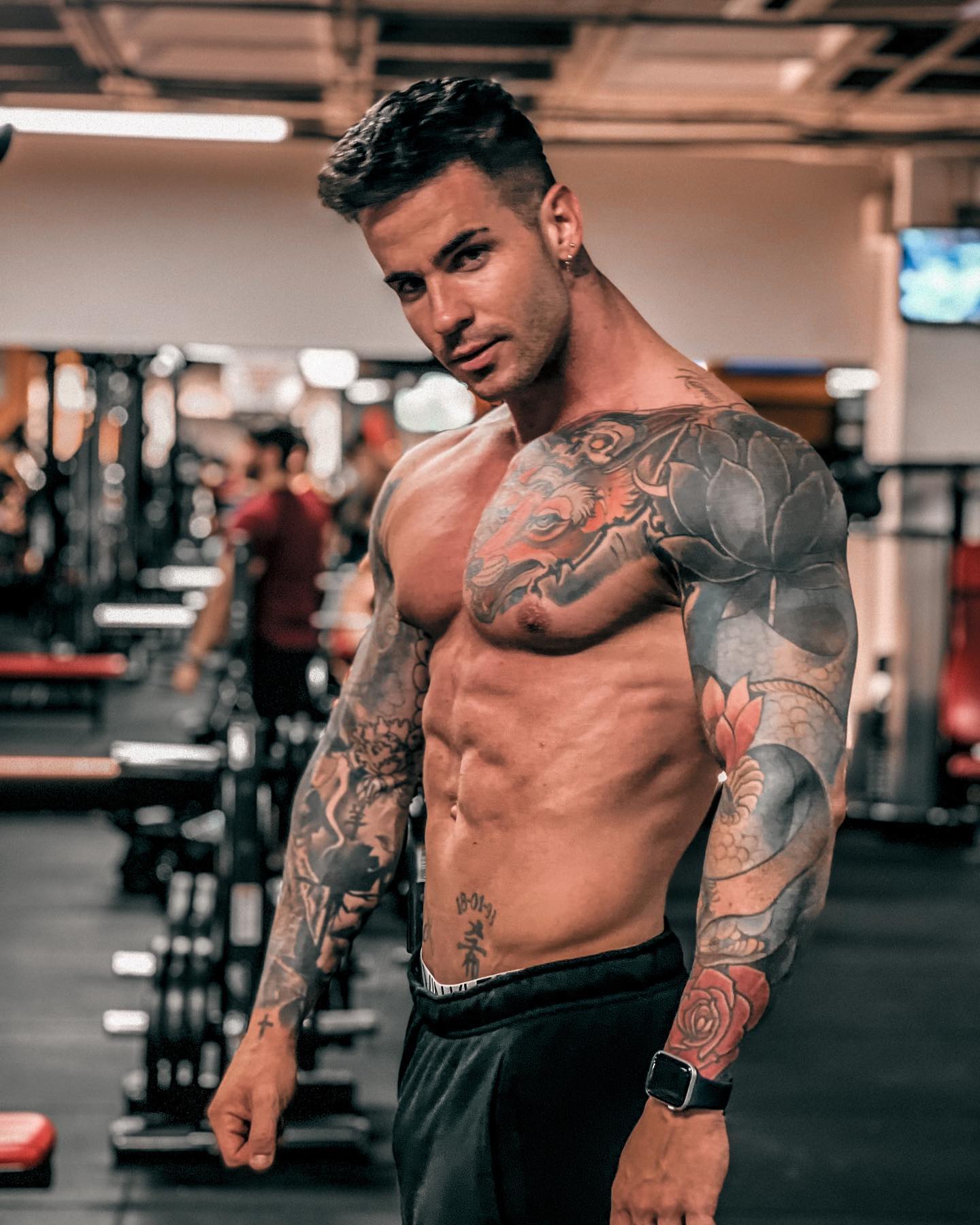 Alex Bueno, en el gimnasio mostrando su escultural figura fitness y tatuajes