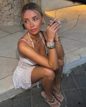 Hermosa influencer digital Corinna Kopf posando con elegante vestido rosa pálido y lujosos accesorios