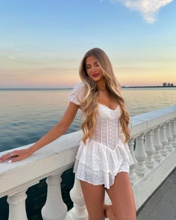 Victoria Rozmajzl posando junto al mar con un vestido blanco