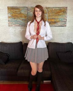 Lollipop Ginger con uniforme escolar, falda gris y corbata roja