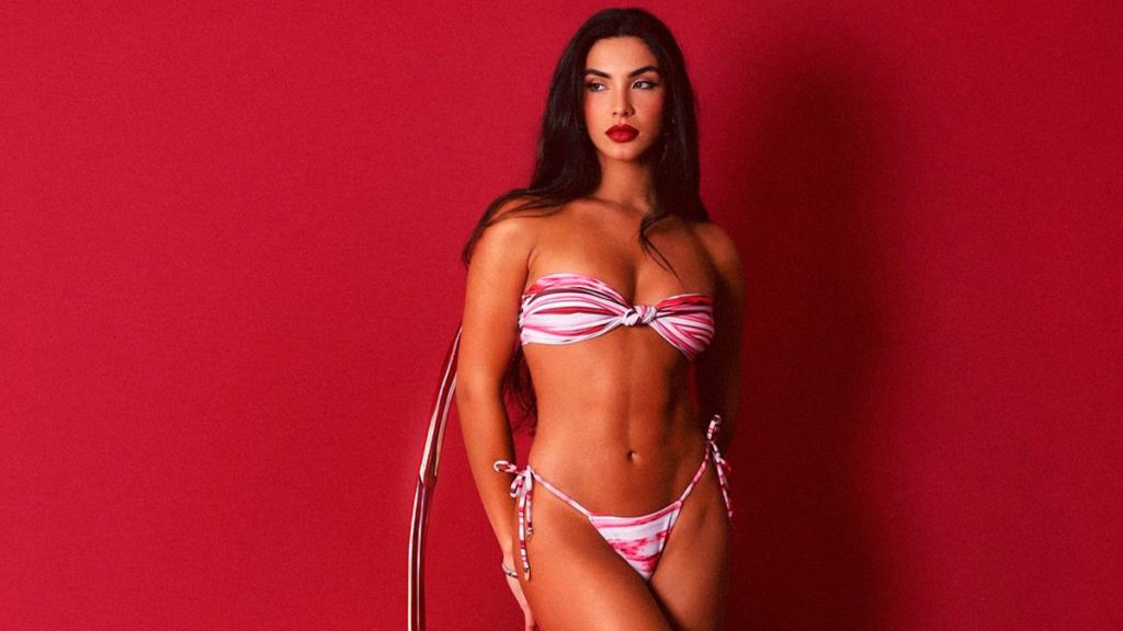 Gabriela Versiani, posando con glamour en bikini y fondo rojo para una sesión fotográfica