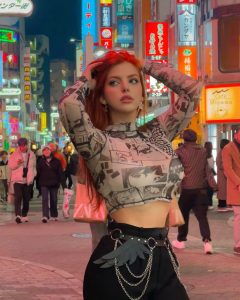 Modelo pelirroja Helen Grube posando con confianza en un concurrido barrio japonés