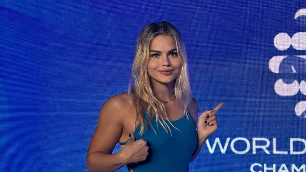 Luana Alonso en traje de baño azul posando frente al logo del Mundial de Natación Doha 2025