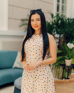Kelly Bustamante luce un elegante vestido de lunares naranjas y negros mientras posa en un entorno natural