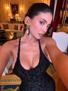 Kylie Jenner posa con un vestido negro de encaje y accesorios dorados en un lujoso entorno