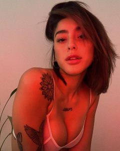 Belén Negri posa con mirada intensa, luciendo body rojo ceñido que resalta su figura curvilínea