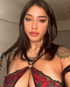 Belén Negri posa con mirada intensa y lencería de encaje negro y rojo que resalta su busto