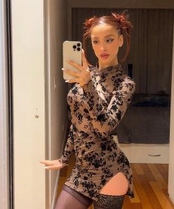 Belén Negri posa con vestido floral de manga larga y maquillaje impactante, acentuando su belleza y estilo