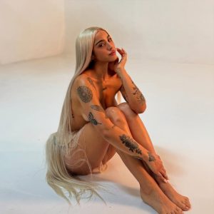 Belén Negri posa sentada con look de lencería negra y transparencias que realza su figura atlética