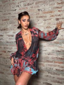 Belén Negri posa con vestido rojo y negro de estampado floral, resaltando su busto con un pronunciado escote