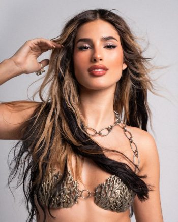 Julieta Poggio con vestido de lentejuelas dorado, cabello ondulado y mirada intensa