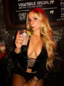 Kaitlyn Krems posa con una minifalda ajustada que realza sus piernas tonificadas y un corset negro que centra la atención en su busto