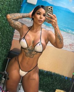 Karishna Ayala se toma una selfie con un bikini de tonos claros y detalles brillantes, posando frente a un fondo de vegetación y cielo azul