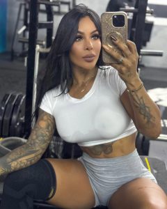 Karishna Ayala posa con mirada intensa, luciendo crop top y minifalda blanca que resaltan su figura atlética