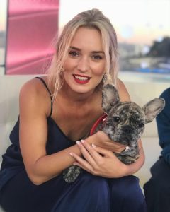 Kika Silva sonriendo y sosteniendo a un lindo perro en brazos