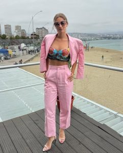Kika Silva posa con estiloso conjunto rosa, lentes de sol y actitud desenfadada en pasarela con vista a la ciudad