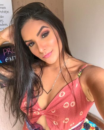 Luanna Araujo tomando selfie con vestido rosa y maquillaje natural